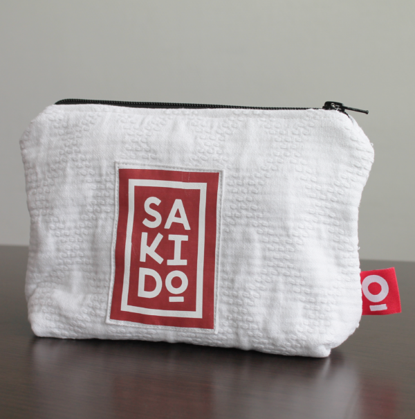 Une Trousse YUKI texturée blanche avec un logo rouge et blanc Sakido